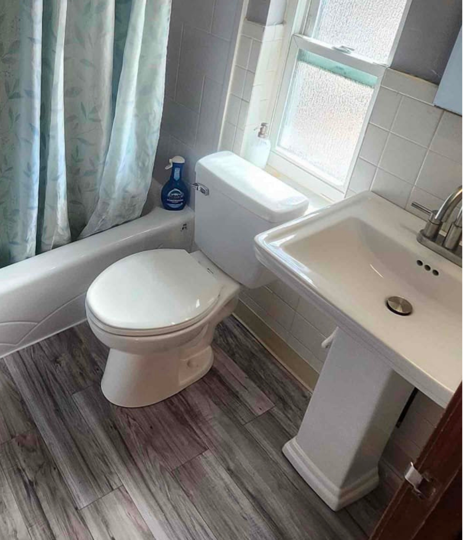 Repaired subfloor with new flooring, pedestal sink, and toilet — after Wahl repair